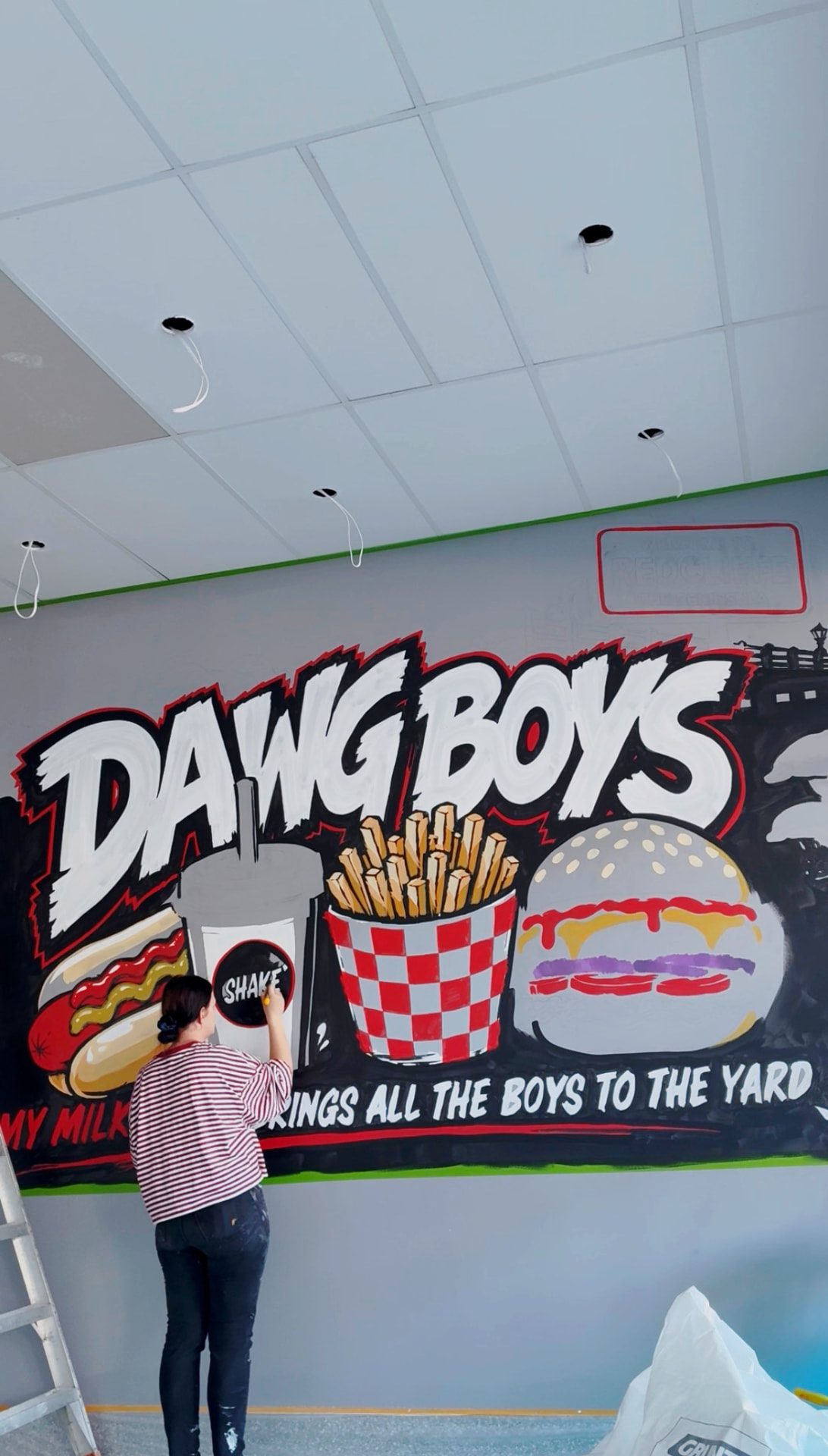 Ashleigh, Brisbane mural artist behind Your Local Mural, painting the DawgBoys mural on site