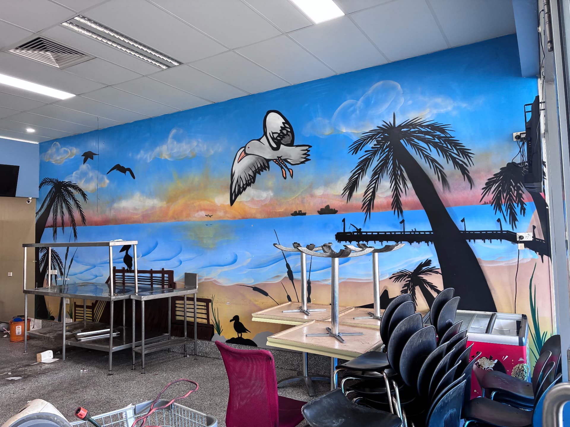 The DawgBoys wall in Redcliffe before the transformation, an old beach mural with palm trees and a pelican