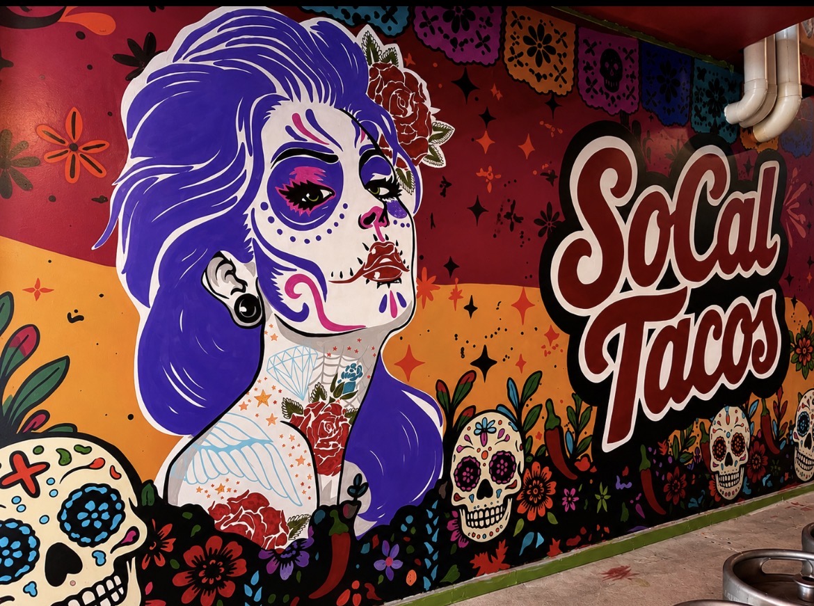 Hand-painted Señorita portrait with purple hair and sugar skull face paint beside the SoCal Tacos lettering